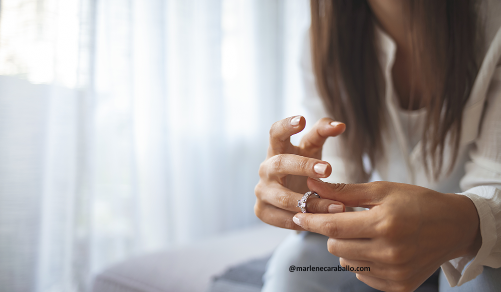 Divorce at the start of a new year divorce coach services image of a woman removing her wedding ring