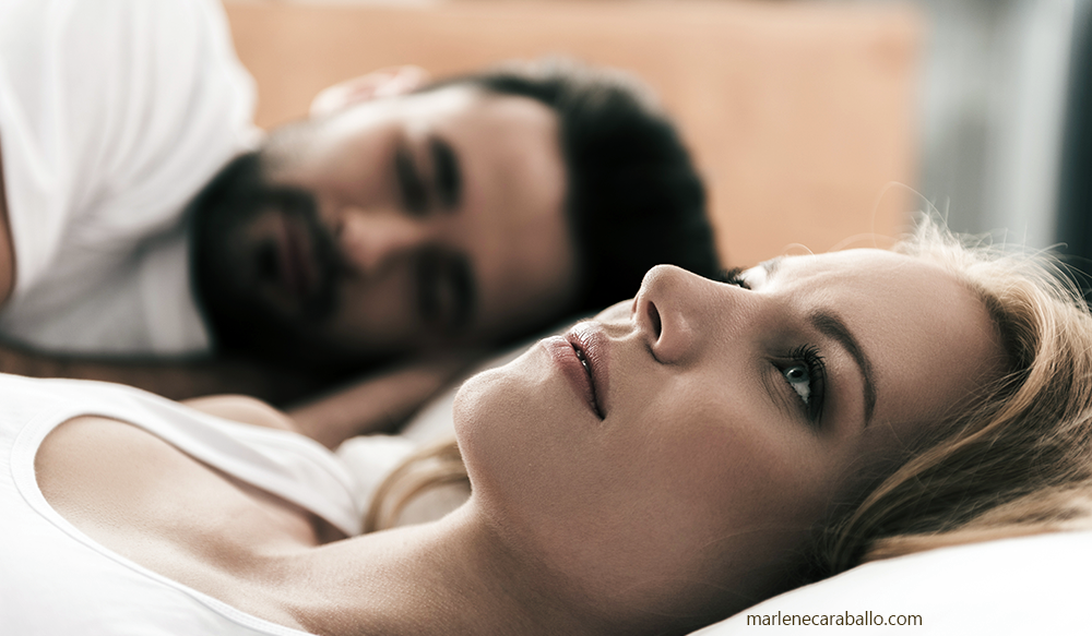 Woman laying in bed worrying about her unhappy marriage