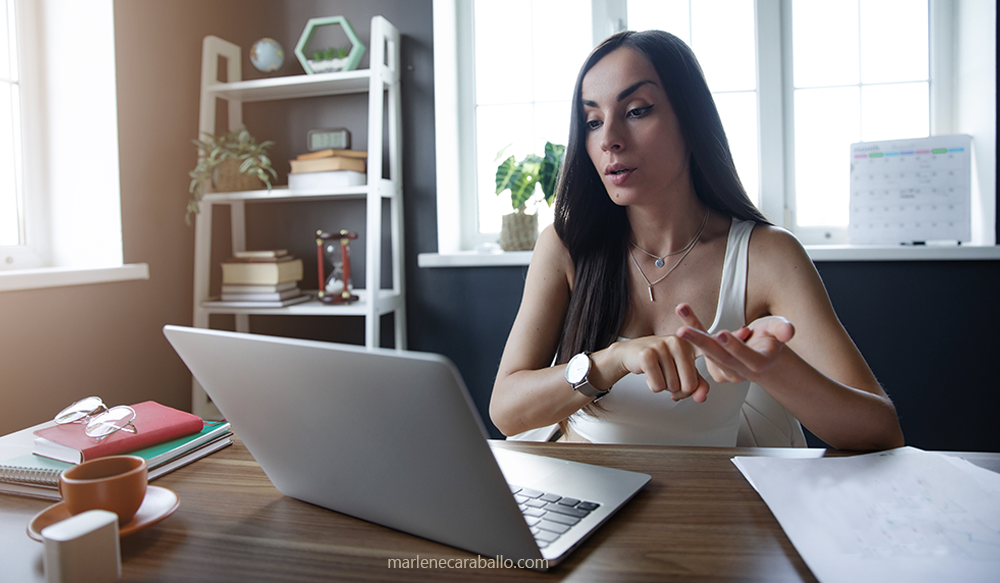 Woman on a virtual meeting with her divorce attorney, notes and paperwork on the desk